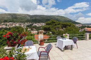 a patio with tables and chairs and a view of a city at Guest House Raguž in Dubrovnik