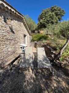 two benches and a table in front of a building at gite du mouredon in Vallon-Pont-dʼArc +2 photos