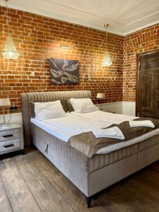 a bedroom with a large bed in a brick wall at Apartament 511 Gold AC Progres in Toruń