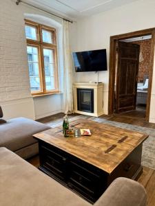 a living room with a coffee table and a tv at Apartament 511 Gold AC Progres in Toruń