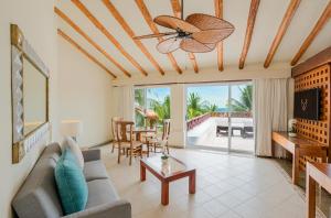 Una sala de estar con un sofá y un ventilador de techo. en Desire Pearl Riviera Maya Resort All Inclusive - Couples Only, en Puerto Morelos
