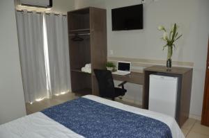 a bedroom with a bed and a desk with a laptop at Palace Hotel in Altamira +47 photos