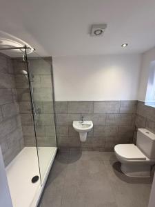 a bathroom with a shower and a toilet and a sink at Oakwood Farm Barns in Chester +7 photos