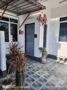 パンタイチェナンにあるLaman Hanaz - Homestay Auniの青い扉と鉢植えのポーチ +21枚の写真