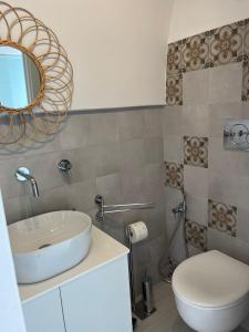 a bathroom with a sink and a toilet and a mirror at Affittacamere Nalì in Polignano a Mare
