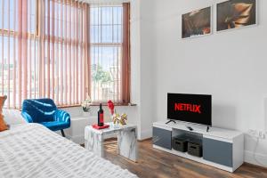 a bedroom with a tv and a bed and a chair at Leicester1BR-WiFi-ModernApt-Kitchen-Sleeps2 in Leicester