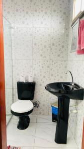 a bathroom with a black sink and a toilet at Sobrado_Familiar in Boa Vista +19 photos