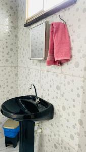 a bathroom with a black sink and a pink towel at Sobrado_Familiar in Boa Vista
