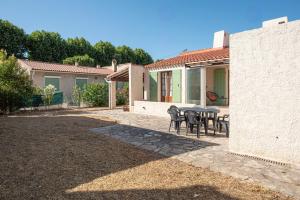 a patio with a table and chairs in a yard at Maison Olivier Confort et Modularité in Istres