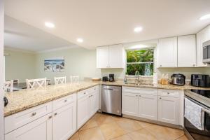a white kitchen with white cabinets and a window at Relaxing place with pool in Cape Coral