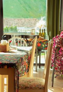 a dining room with a table and chairs and a window at Aronia Kazbegi in Stepantsminda