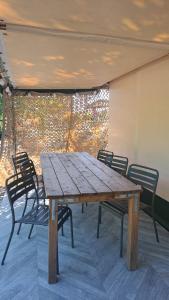 a wooden table and chairs on a patio at Les 2 étangs de la foulonnerie in Saint-Jean-Saint-Germain