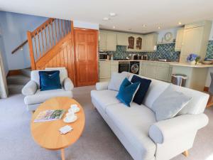 a living room with two couches and a table at Lakeside Cottage in Windermere