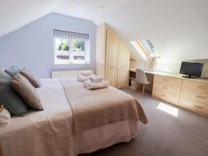 a bedroom with a bed with towels on it at Lakeside Cottage in Windermere