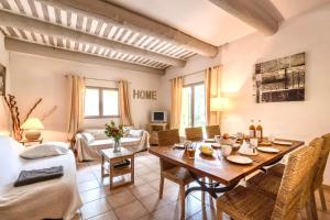 a living room with a wooden table and chairs at Ferme Fortia in Montréal-les-Sources
