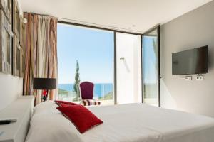 ein Schlafzimmer mit einem Bett und einem großen Fenster in der Unterkunft Luxury Villa with Private Pool, Ibiza Villa 1267 in Santa Eulària des Riu