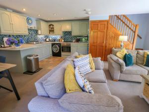 a living room with a couch and a kitchen at Waterhead Cottage in Windermere