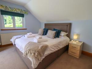 a bedroom with a large bed with towels on it at Waterhead Cottage in Windermere