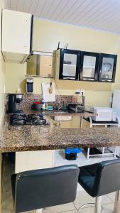a kitchen with a counter with a sink and a stove at Kitnet_Familiar 2/4 in Boa Vista