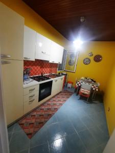 cocina con paredes amarillas y armarios blancos en Balcone sul mare di sciacca, en Sciacca