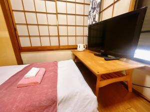 a bedroom with a bed and a desk with a television at 池袋House2F Cozy for 1-3 guests in Tokyo