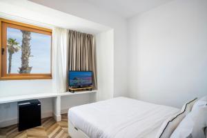 a bedroom with a bed and a window with a television at Duna Hotel Boutique in Peñíscola