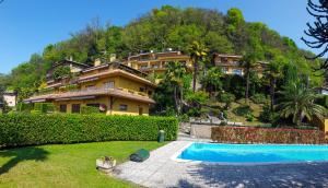 a large house with a swimming pool in front of it at Vista Maccagno in Maccagno Inferiore