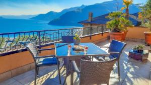 une table et des chaises sur un balcon avec vue sur l'eau dans l'établissement Vista Maccagno, à Maccagno Inferiore 15 autres photos