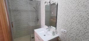 un bagno con lavandino, doccia e specchio di Chalet de artistas a Vadocondes Altre 58 foto