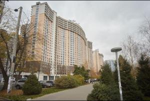 a large building with cars parked in front of it at Arcadia Apartments in Odesa