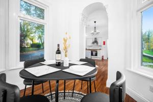 a dining room with a table with a bottle of wine at Cozy Apartment - Wolverhampton - High-Speed Internet 9PC in Wolverhampton