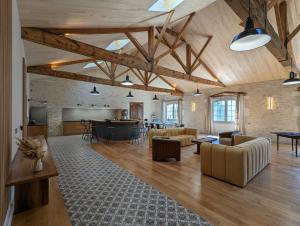 a large living room with wooden ceilings and furniture at Maison Prunier in Jarnac