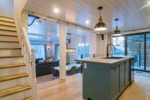 an open kitchen and living room with a staircase at Maison 3 chambres à coucher vue sur la montagne in Bromont