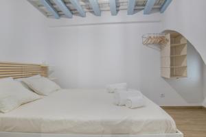 a bedroom with a white bed with two white towels at Casita Luna in Vejer de la Frontera