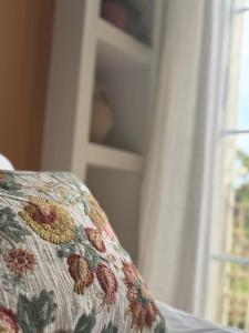 a close up of a couch with a floral pillow at Chambre d'hôtes Villa Calys in Claira