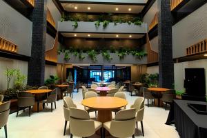 a restaurant with tables and chairs and plants at Flat à beira-mar Beach Haus - MyFlats Hospedagens in Tambaú