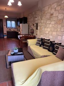 a living room with two couches and a stone wall at Afytos house in Afitos