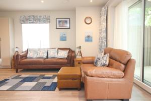 a living room with a couch and a chair at Secluded two bedroom apartment in Padstow +3 photos