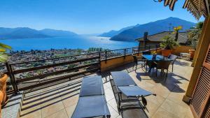 a balcony with tables and chairs and a view of the water at Vista Maccagno in Maccagno Inferiore