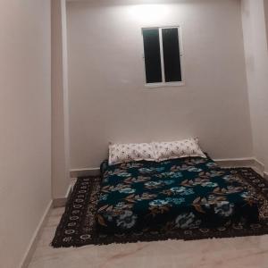 a bedroom with a bed and a rug on the floor at Rajkumar home stay in Ujjain