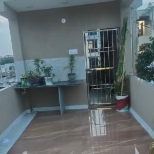 a balcony with a gate and potted plants at Rajkumar home stay in Ujjain