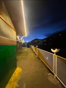 a view of a balcony of a building at night at Himalayan Wooden Cottage & Cafe Dalhousie in Dalhousie