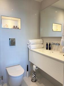 a bathroom with a toilet and a sink and a mirror at Headland View Boutique B&B in Torquay +46 photos