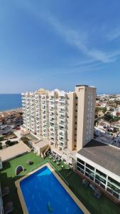 duży budynek apartamentowy z dużym basenem w obiekcie Destinos de Sol La Minería Roquetas de Mar w mieście Roquetas de Mar