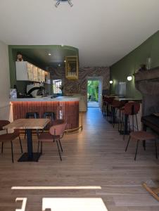 a restaurant with a bar and tables and chairs at Le Saint-Georges in Saint-Georges-de-Mons