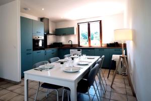 una mesa blanca en una cocina con armarios azules en Welcome Home, en Vert-le-Grand