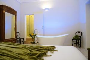 a bedroom with a tub and a bed and a mirror at Palazzo Sozzi Luxury - ANTICO SPLENDORE nel CUORE di OSTUNI in Ostuni