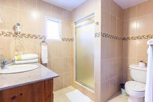 a bathroom with a toilet and a sink and a shower at Alicia Beach, Hispaniola Sol, great location - no car needed! in Sosúa +13 photos