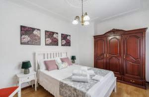 a bedroom with a large bed and a wooden cabinet at Casa Corredoura in Ponte de Lima