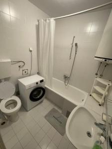 a white bathroom with a toilet and a sink at Apartman Herceg Novi in Herceg-Novi